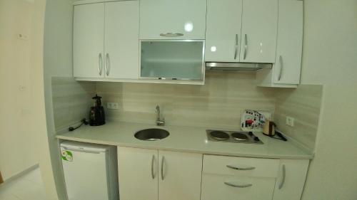 a small kitchen with a sink and white cabinets at Arti̇m Apart Hotel in Fethiye