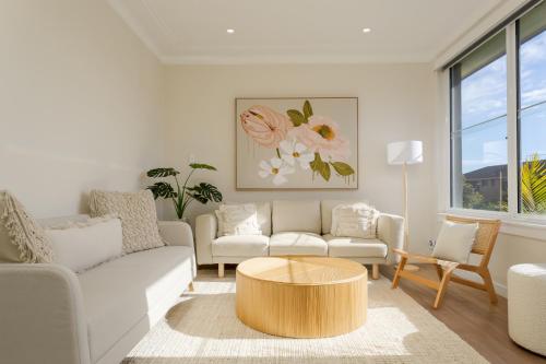 a living room with a couch and a coffee table at Idyllic 4-Bed Home With Alfresco Area Near Beach in Deewhy