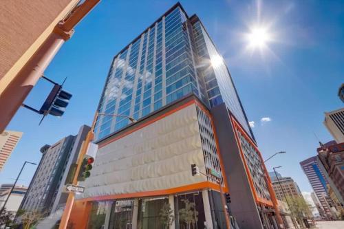 a tall glass building on a city street at Boulevard Stays Highrise STU Sky Pool Parking Gym 28 in Phoenix