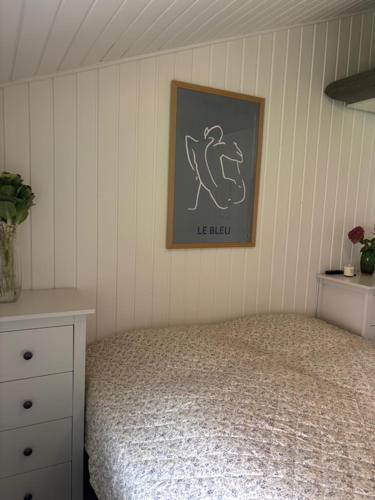 a bedroom with a bed and a picture on the wall at FF1006 Autentisk Feriebolig i Hemmet med adgang til pool in Hemmet