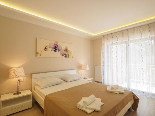 Un dormitorio con una cama con dos toallas encima. en Villa Petra Selce, en Selce