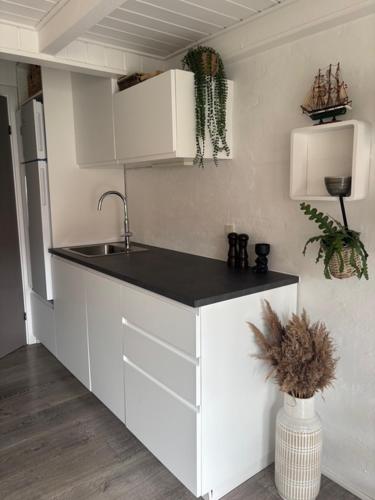 a kitchen with white cabinets and a sink at FF1006 Autentisk Feriebolig i Hemmet med adgang til pool in Hemmet