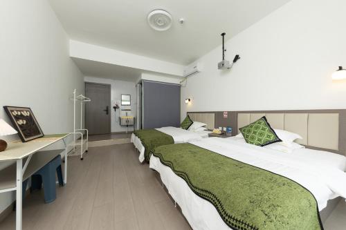 a hospital room with two beds and a desk at Shuju B&B Hotel in Kunming