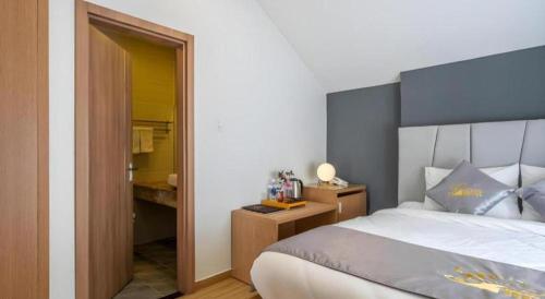 a bedroom with a large bed and a bathroom at Gold View Boutique Hotel Đà Lạt in Da Lat