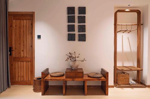 a room with a table with a vase on it at M Country Road 山行野奢影院温泉民宿 in Dujiangyan