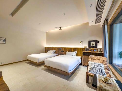 a bedroom with two beds and a couch at M Country Road 山行野奢影院温泉民宿 in Dujiangyan