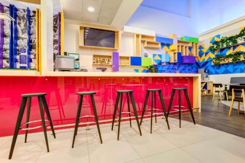 a colorful bar in a restaurant with stools at Ibis Styles Mexico Reforma in Mexico City