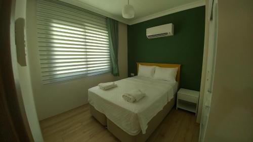 a small bedroom with a bed and a window at Arti̇m Apart Hotel in Fethiye