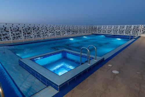 a large swimming pool with blue water in a building at Sunday Jeddah Hotel in Jeddah
