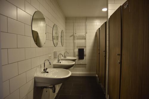 a bathroom with two sinks and two mirrors at Buitengewoon Overnachten in Terheijden