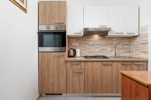 a kitchen with wooden cabinets and a stove top oven at Molo Longo - Downtown Apartments in Rijeka