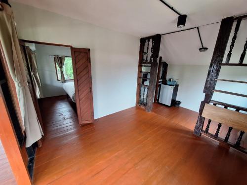 an empty room with a wooden floor and a door at The Seasons At Pai in Pai