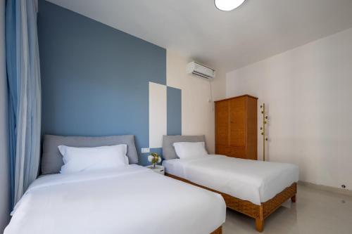 two beds sitting next to each other in a room at Sanya Sun Seaview Apartment in Sanya