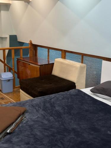a bedroom with a bed and a chair and a piano at Квартира на огонбаева in Bishkek