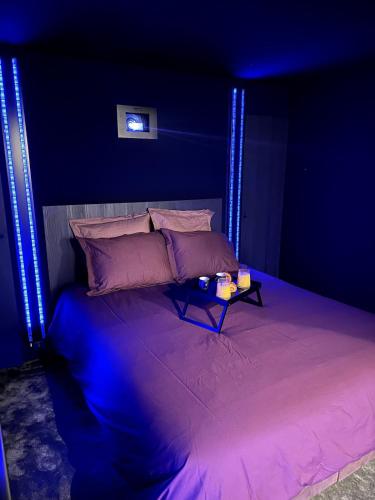 a bedroom with a bed with blue lights on it at Ciné-Ponot in Le Puy-en-Velay