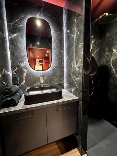 a bathroom with a sink and a mirror at Ciné-Ponot in Le Puy en Velay