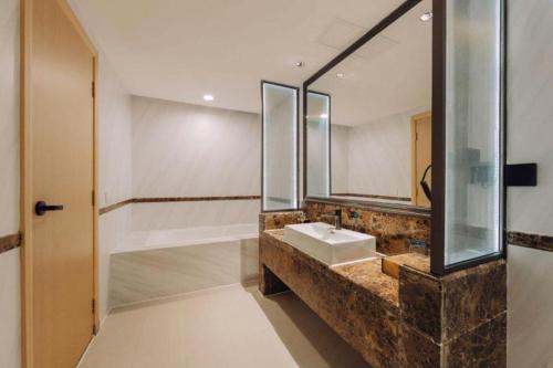 a bathroom with a sink and a mirror at Vienna International Hotel Guangzhou Huangpu in Guangzhou