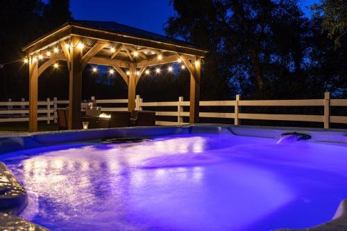 a hot tub in a yard with a gazebo at night at Yosemite and Bass lake I Hot tub I Game room I Sleeps 13 in Oakhurst