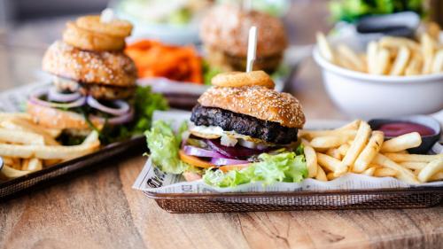 a sandwich and french fries on a wooden table at Darwin FreeSpirit Resort in Darwin