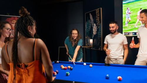 a group of people standing around a pool table at Darwin FreeSpirit Resort in Darwin