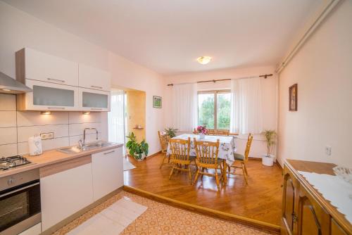 a kitchen and dining room with a table and chairs at Apartment Anica in Rab
