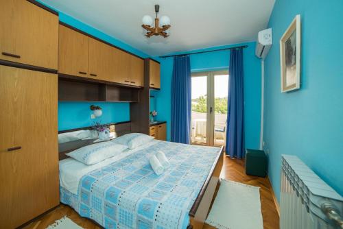 a blue bedroom with a bed with a blue wall at Apartment Anica in Rab