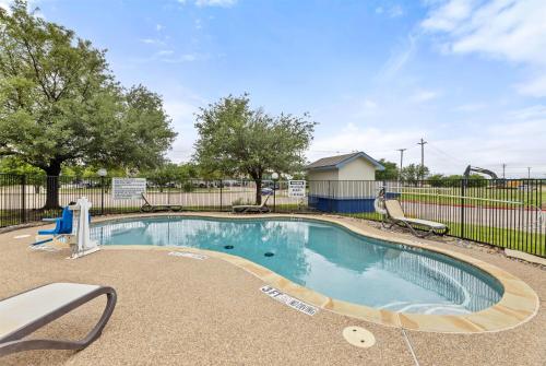 a swimming pool with a slide and a playground at Days Inn by Wyndham McKinney in McKinney