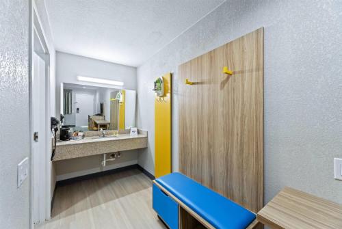 a room with a bathroom with a sink and a mirror at Days Inn by Wyndham McKinney in McKinney