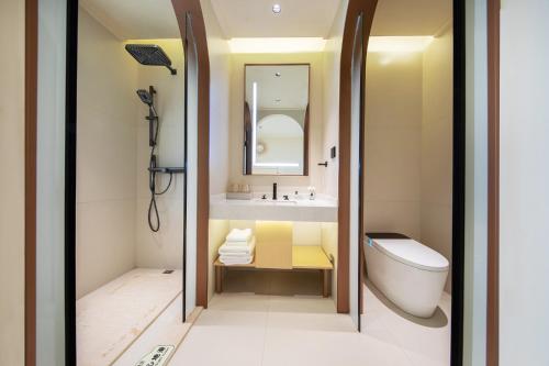 a bathroom with a tub and a sink and a toilet at Caroline Designer Hotel, Gaozhuang, Xishuangjing in Jinghong