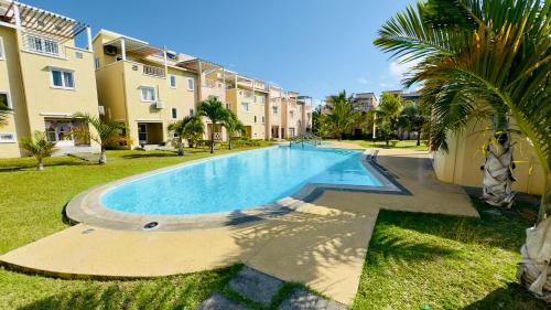 a swimming pool in a yard next to a building at Zephyr House Ocean Breeze with Pool in Grand Gaube