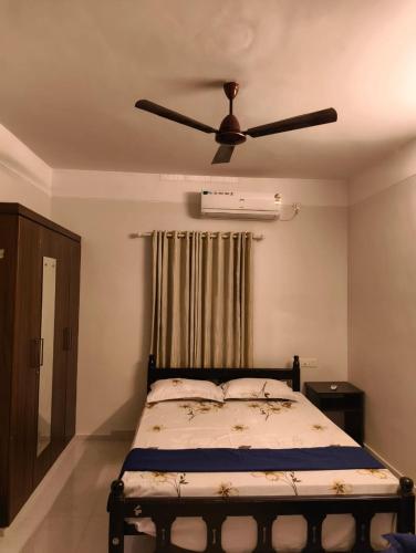 a bedroom with a bed with a ceiling fan at Yatra Homestay in Trivandrum