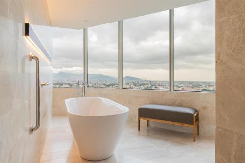 a bathroom with a tub and large windows at Hilton Mexico City Reforma in Mexico City