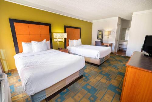 a hotel room with two beds and a television at Travelodge by Wyndham Phoenix North in Phoenix