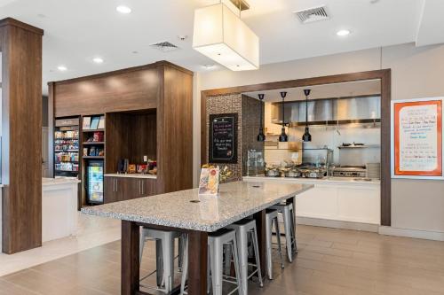 a kitchen with a large island with bar stools at Hilton Garden Inn Martinsburg in Martinsburg