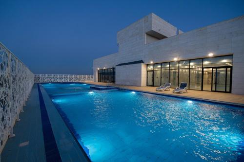 a swimming pool in front of a building at night at Dancenter Jeddah Near King Fahd's Fountain in Jeddah