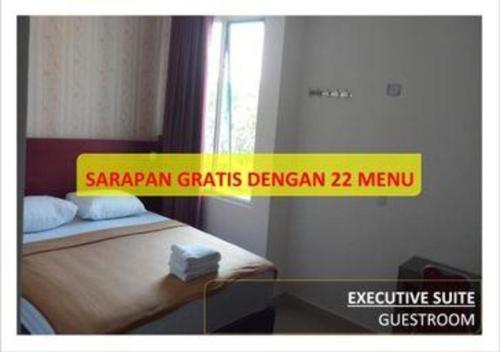 a room with a bed with a yellow sign on it at Hotel 95 in Pontianak