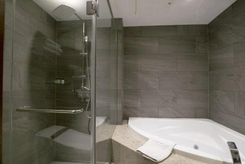 a bathroom with a shower and a tub and a sink at Hotel Venue-G Seoul in Seoul