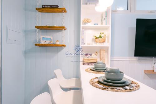 a room with a counter with plates and a tv at Cove Hideaway at Mesavirre in Bacolod