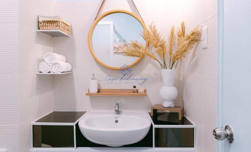a bathroom with a sink and a mirror at Cove Hideaway at Mesavirre in Bacolod