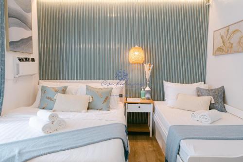 two beds in a room with blue and white stripes at Cove Hideaway at Mesavirre in Bacolod