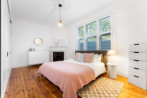 une chambre blanche avec un lit et une cheminée dans l'établissement Herringbone Cottage - Unique Garden Escape CBD, à Fullarton