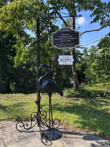 a statue of a bird on a pole with a happy sign at The Highland Oasis in Ephrata