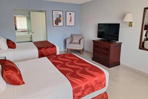 a hotel room with two beds and a flat screen tv at Quality Inn Piedras Negras in Piedras Negras