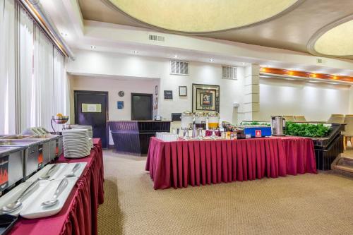 a banquet hall with two tables with red table skirts at Quality Inn Piedras Negras in Piedras Negras