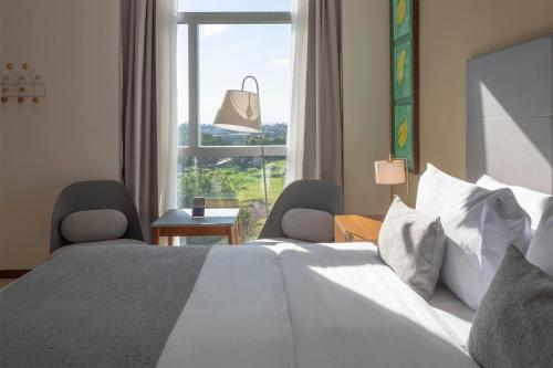 a bedroom with a bed and a large window at Dazzler by Wyndham Ciudad del Este in Ciudad del Este