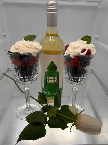 two glasses ofifle with a bottle of wine and berries at The Highland Oasis in Ephrata