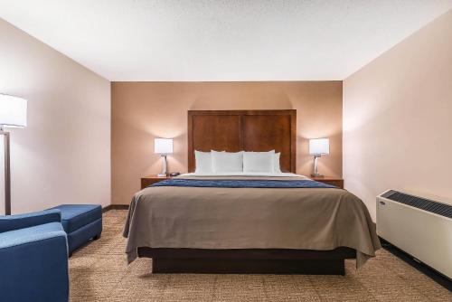 a hotel room with a bed and a blue couch at Comfort Inn Concord South End in Concord