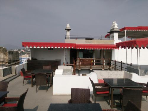 a restaurant with tables and chairs on a roof at Madri Haveli in Udaipur