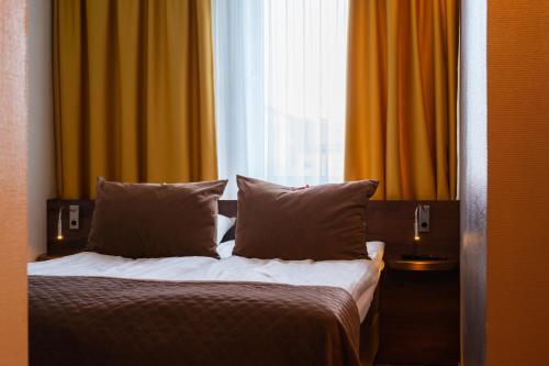 a bedroom with a bed with pillows and a window at Northern Light Hotel in Boden