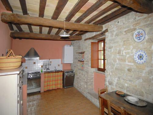 a kitchen with a table and a stone wall at Farmhouse in Apecchio with Pool and Terrace in Apecchio